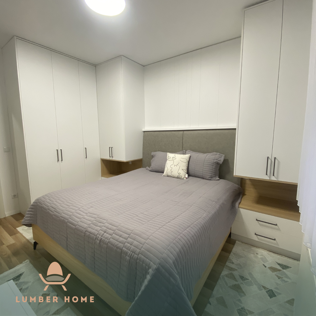Bedroom with white fitted wardrobes around the bed
