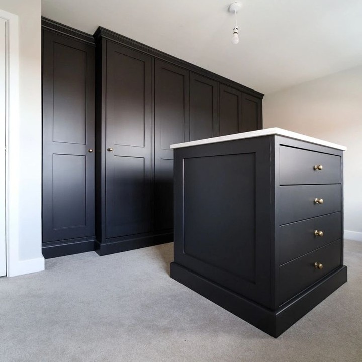 Black dressing room with full-height wardrobes and a drawer island