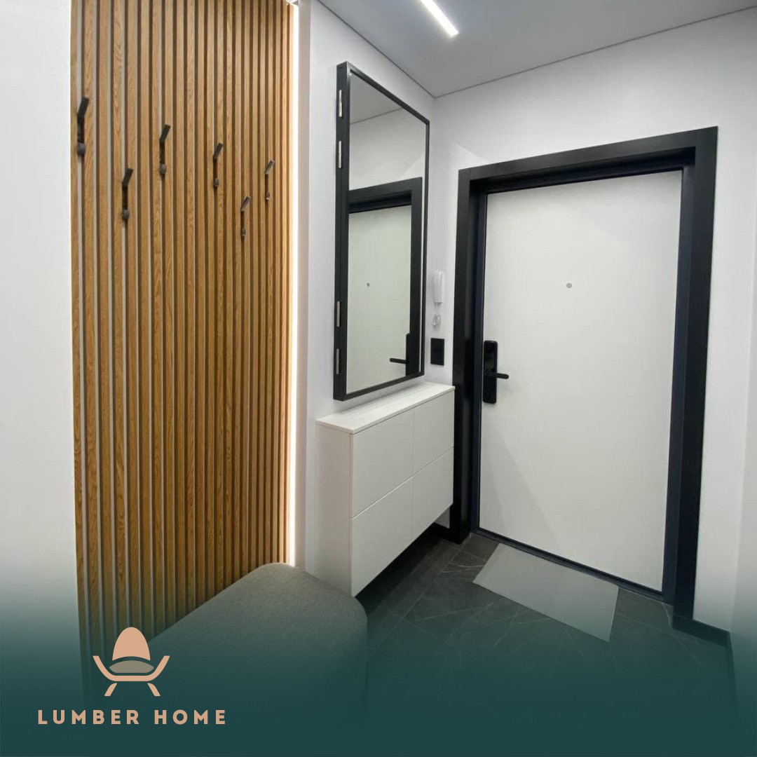 Hallway with oak slatted panelling, hooks and a black-framed mirror